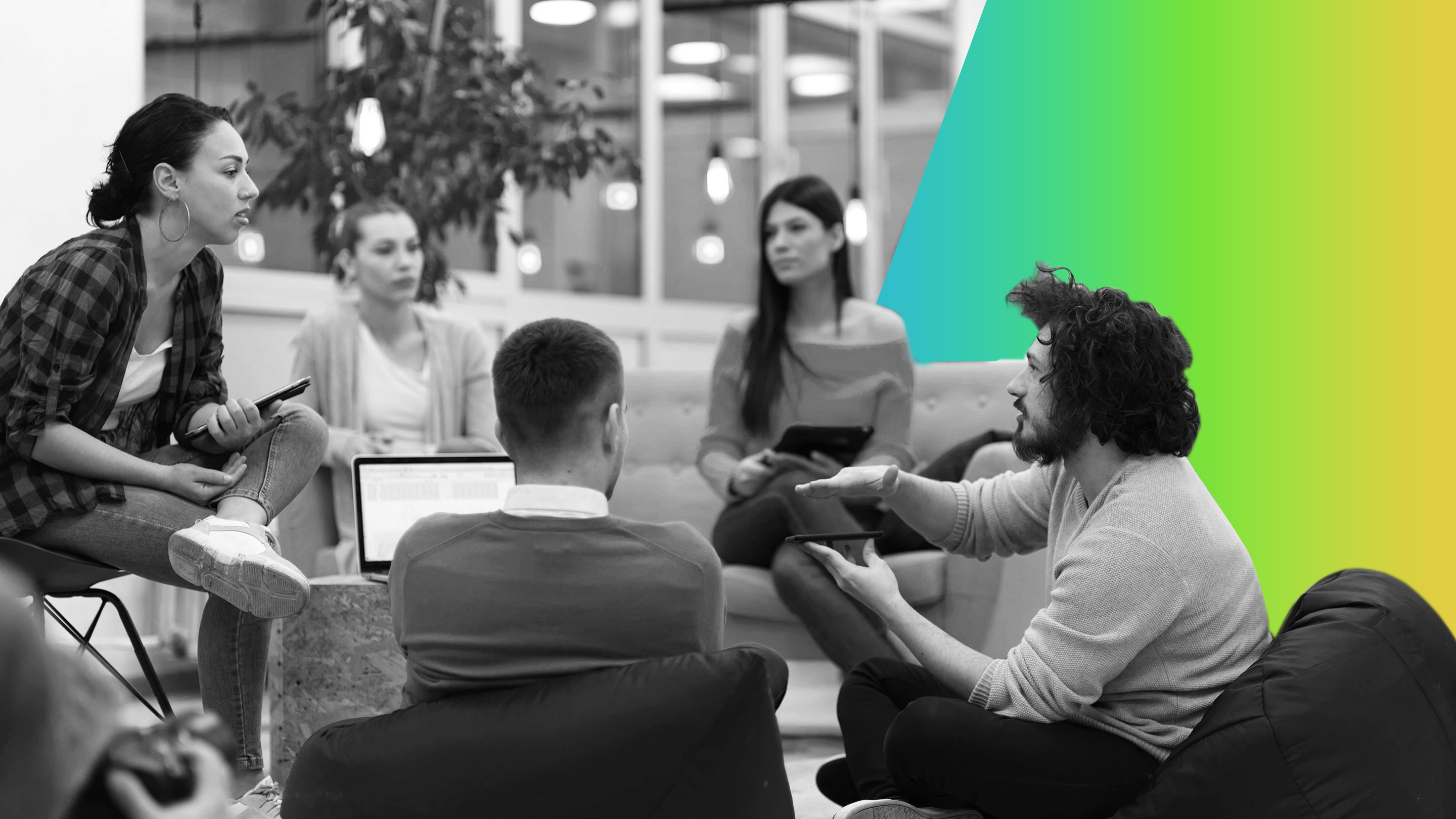 Grupo de jóvenes profesionales sentados en círculo en una oficina moderna, conversando